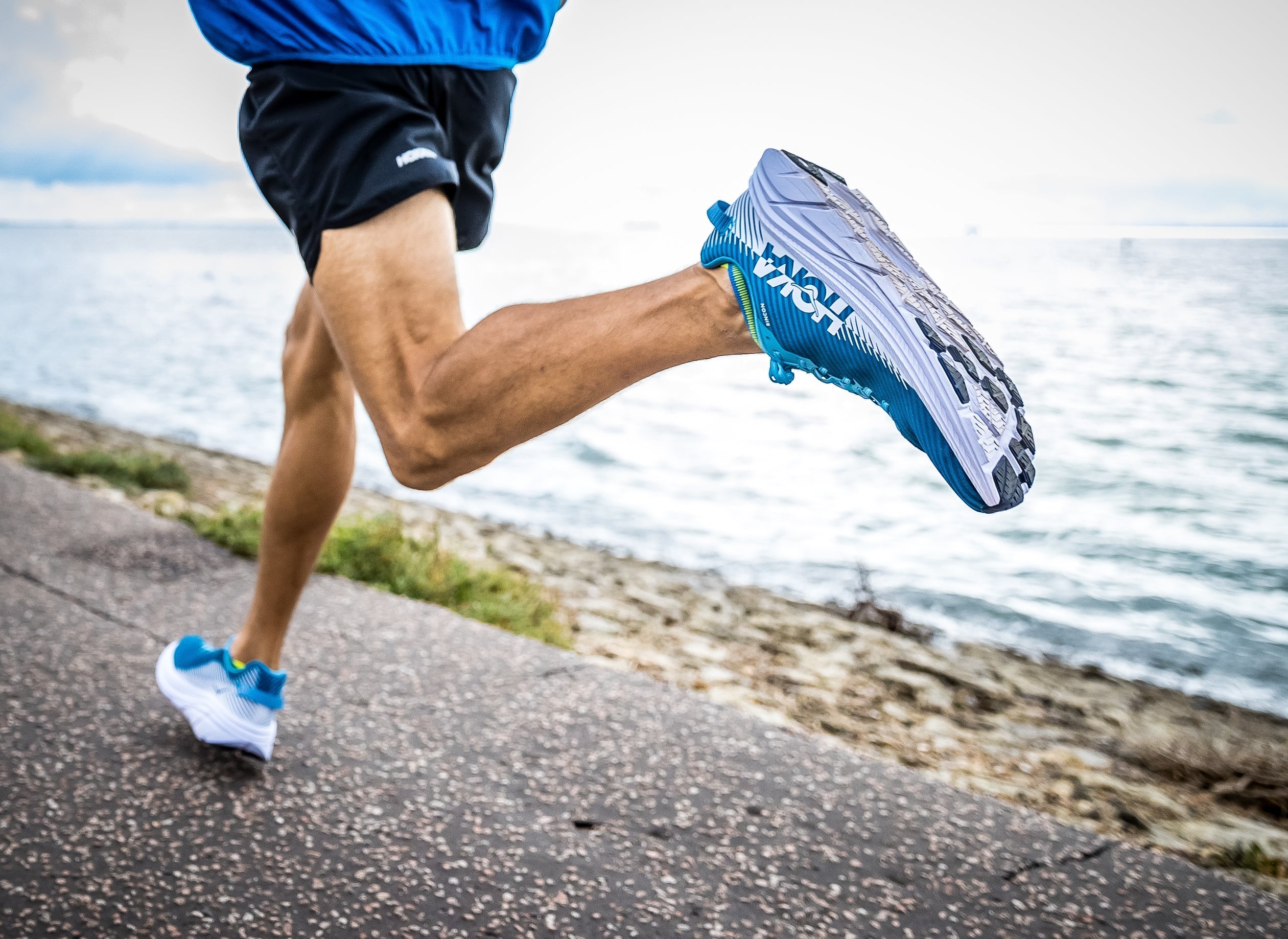 Runner in motion on an outdoor trail, demonstrating proper running form and athletic focus.